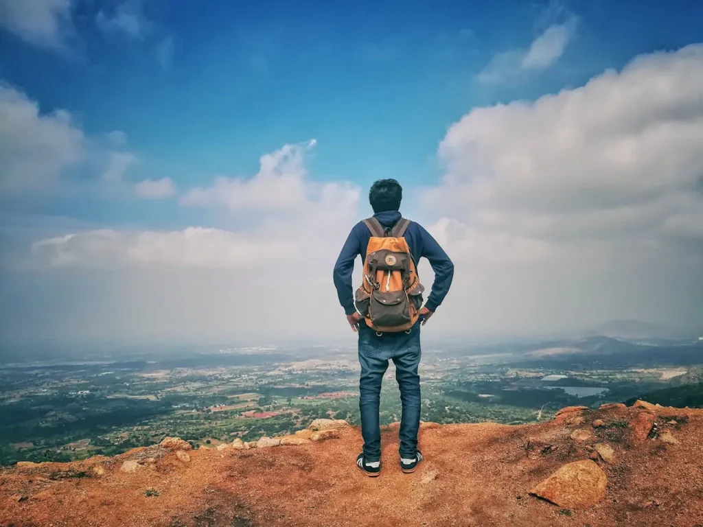 Man in Blue Dress Shirt Standing On The Mountain